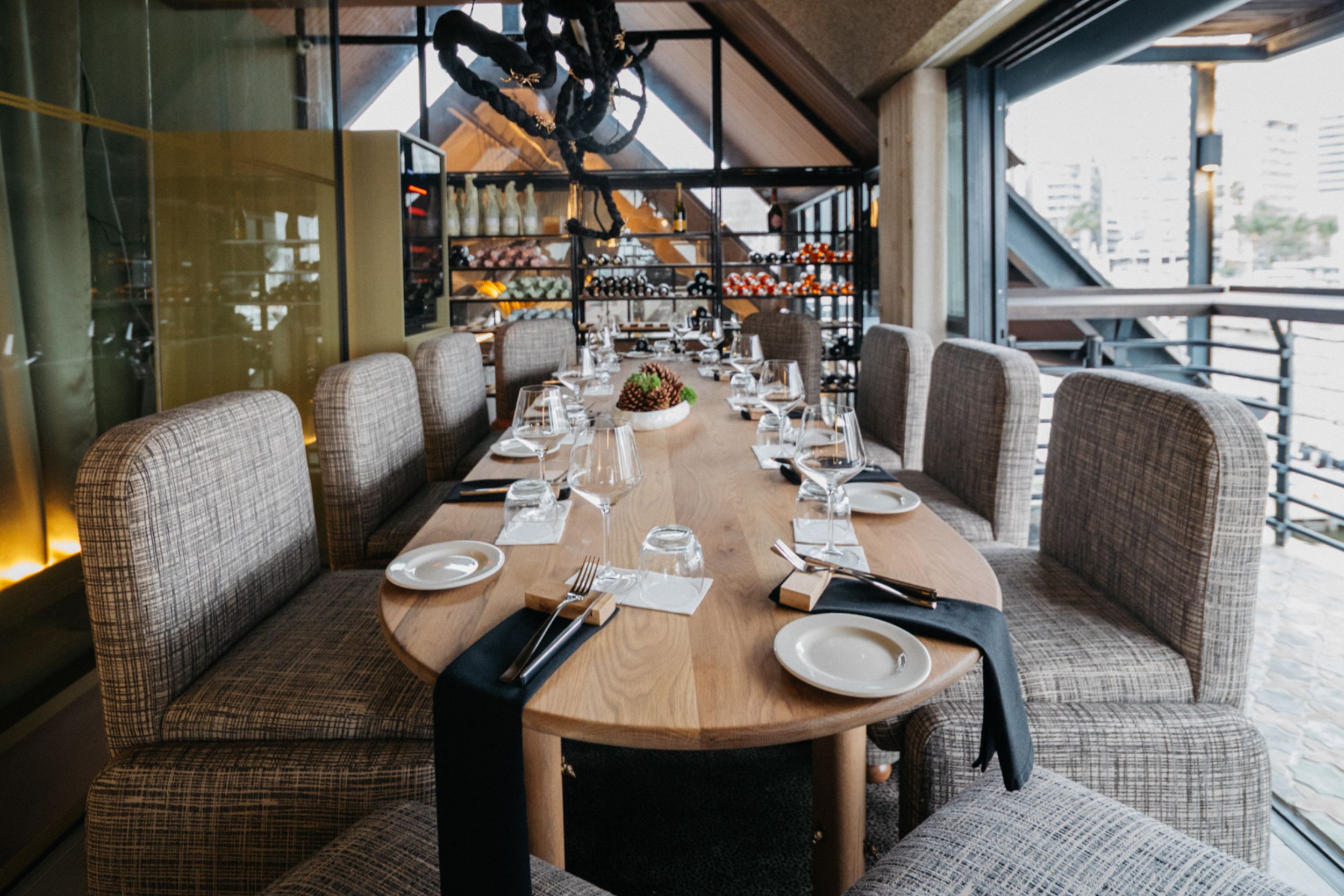 An intimate wine-cellar dining nook, floor-to-ceiling wine racks, for a small private group.